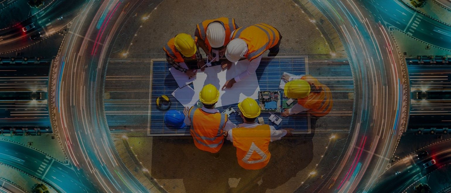 Bauleitung und Planungsteam besprechen Pläne auf einer Baustelle, Blick von oben