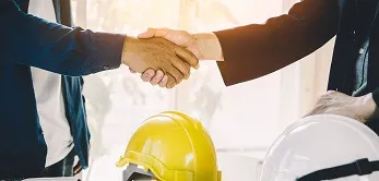 Architekt und Auftraggeber geben sich auf der Baustelle die Hand